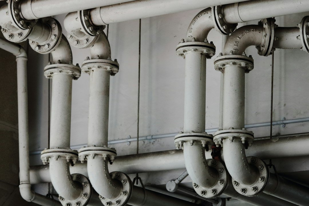 Metal water pipes above a ceiling being checked for a leak