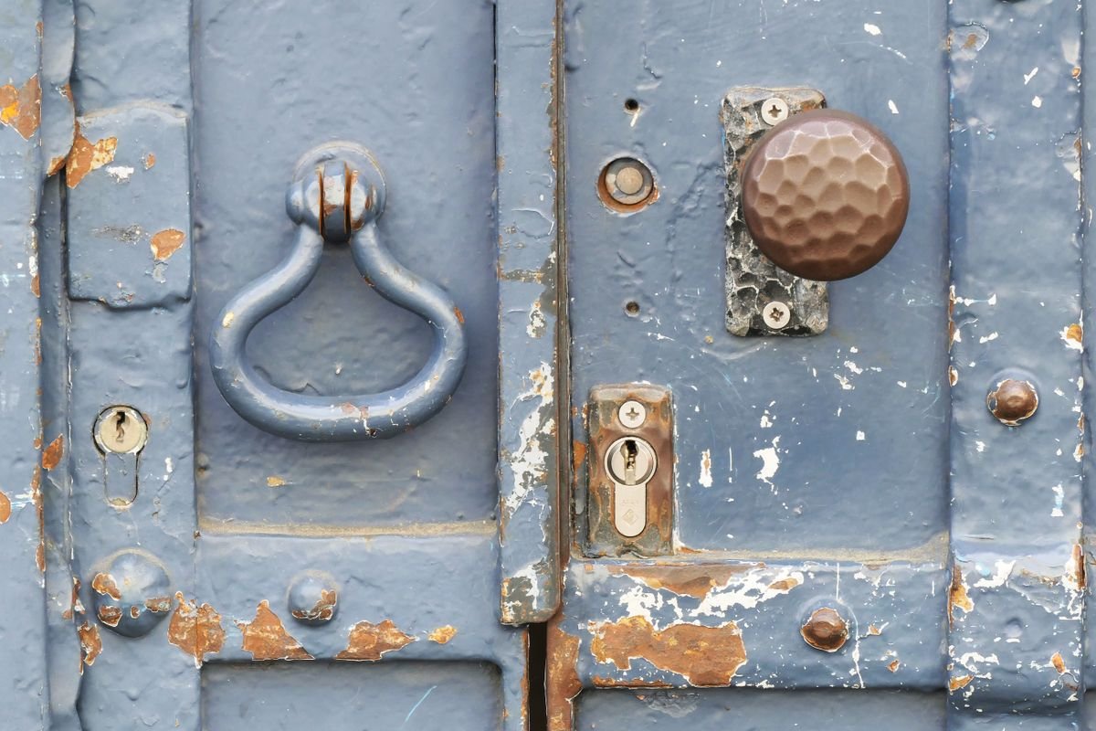 Close-up of an older door lock and handle being checked